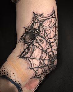 a spider web tattoo on the arm