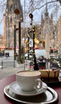 a cup of coffee sitting on top of a saucer next to a glass window