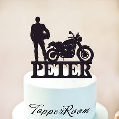 a cake topper that has a motorcycle on it and the words peter written in black