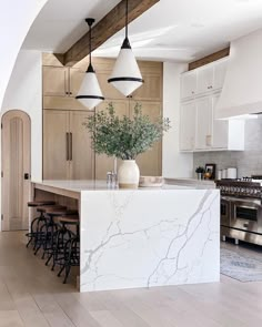 a kitchen with marble counter tops and stools next to an island in the middle