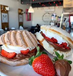 two sandwiches with chocolate and strawberries on a plate