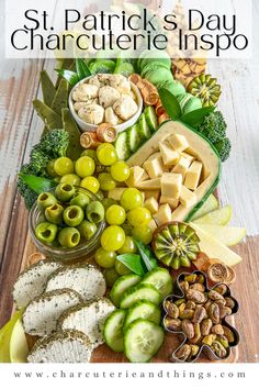 an assortment of cheeses, crackers and olives on a wooden platter