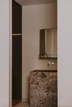 a bathroom with a marble sink and mirror on the wall next to an open door