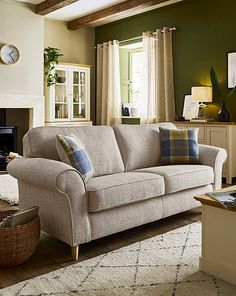 a living room scene with focus on the couch and chair, coffee table and fireplace