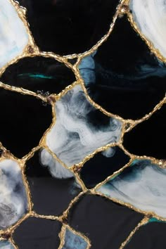 a close up view of some black and white glass with gold foiling on it