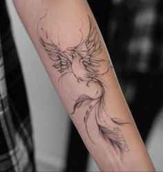 a woman's arm with a tattoo on it that has an image of a bird