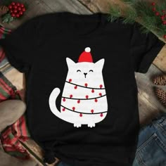 a black shirt with a white cat wearing a santa hat