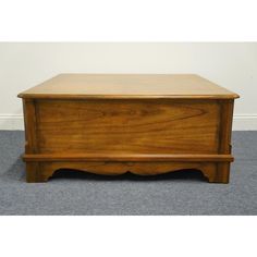 a wooden chest sitting on top of a carpeted floor