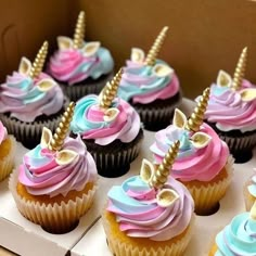 a box filled with cupcakes covered in frosting and topped with colorful icing