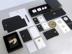 black and white stationery with gold accents on a table next to an open notebook