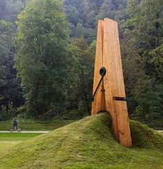 a large wooden object sitting on top of a lush green field