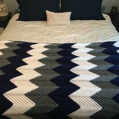 a bed with a blue and white blanket on top of it