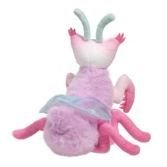 a pink stuffed animal with horns and wings on it's back, sitting in front of a white background