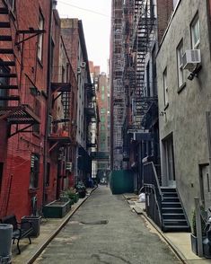 an alley way with fire escapes and stairs