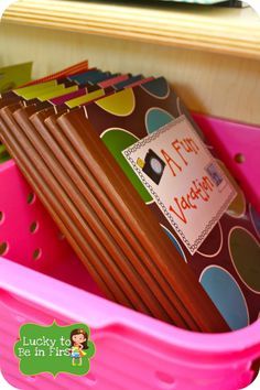 a pink bin filled with lots of different colored papers