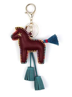 a keychain shaped like a horse with tassels hanging from it's sides