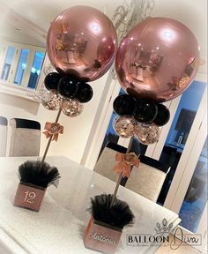 two balloons are on top of each other at the dining room table with black and gold decorations