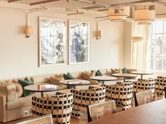 an empty restaurant with tables and chairs in front of large windows that overlook the city