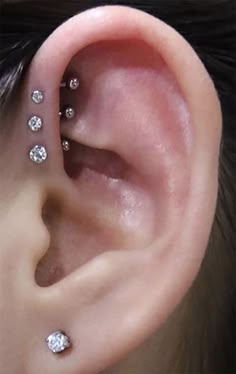 a person with three piercings on their ear