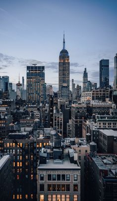 the city skyline is lit up at night, with skyscrapers in the background and lights on