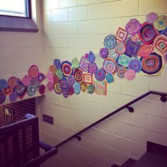 an artisticly designed wall hanging on the side of a stairwell