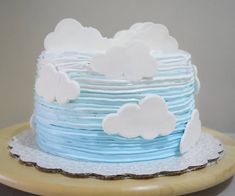 a blue and white cake with clouds on it