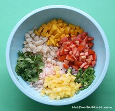 a bowl filled with chopped vegetables on top of a green table