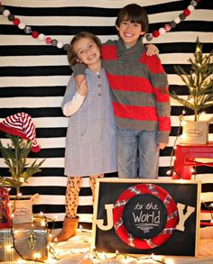 two children standing next to each other in front of christmas decorations