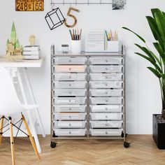 a white desk with lots of drawers next to a potted plant