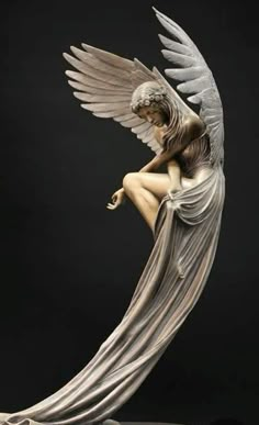 an angel statue sitting on top of a table