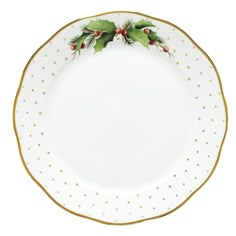 a white and gold plate with holly decorations