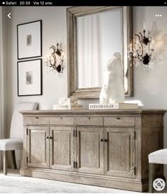 a white teddy bear sitting on top of a dresser next to a mirror and chandelier