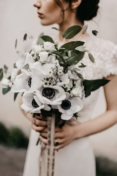 a woman holding a bouquet of flowers in her hands