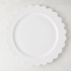 an empty white plate with scalloped edges