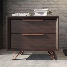 a brown wooden dresser sitting next to a black trash can on top of a cement floor