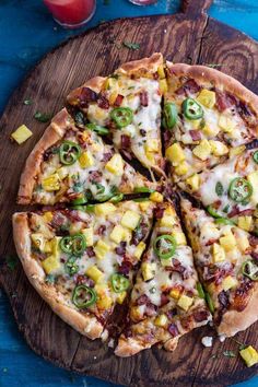 a pizza with several toppings on a wooden cutting board next to a glass of juice