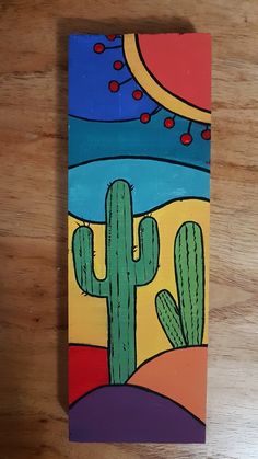 a painting of a cactus on a wooden surface with the colors of the desert in the background