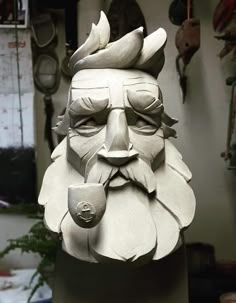 a clay sculpture of a man's face with beard and hat on his head