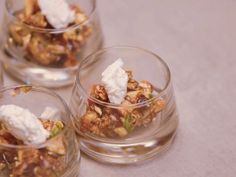 four small glass bowls filled with food on top of a table