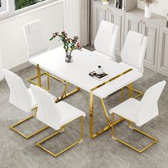 a white and gold dining table with six chairs in the middle, on top of a gray tile floor