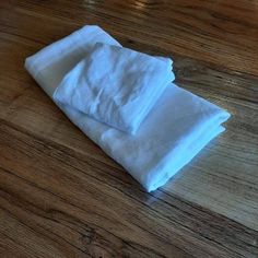 three folded white napkins sitting on top of a wooden table