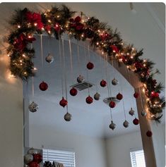 a mirror with christmas decorations hanging from it's sides and lights on the ceiling