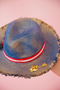 Sail into the summer with our BON VOYAGE SUN HAT! This stylish blue and gold hat features a bold red and white striped ribbon band and a playful gold sailboat pin. Finished with a patriotic red, white, and blue feather combo, it's perfect for any beach day or boat trip. This hat is ONE OF A KIND, created by our owner Stephanie. To receive item quicker, expedited shipping is available at checkout. Red Beach Hat For 4th Of July, Red Hat For Beach And 4th Of July, Red Patriotic Beach Hat, Patriotic Beach Hats For Spring, Patriotic Beach Hat For Spring, Patriotic Hats For Beach In Spring, Patriotic Red Beach Hat, Adjustable Beach Hat For 4th Of July, Patriotic Red Hat For Beach