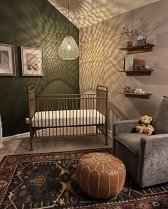 a baby's room with a crib, chair and ottoman