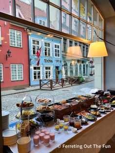 a buffet is set up in front of a large window with lots of food on it