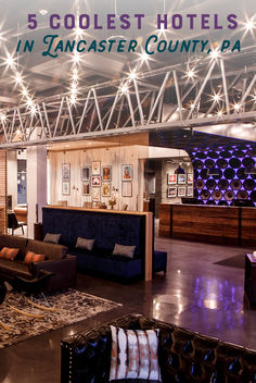 the inside of a hotel lobby with lights on and couches in front of it