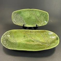 two green plates with leaf designs on them