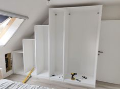 an attic bedroom with built in closets and construction tools on the floor next to it