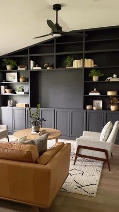 a living room filled with furniture and lots of shelves