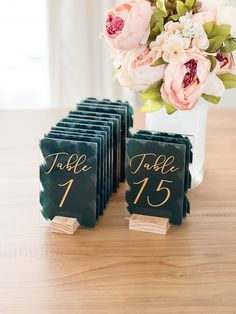 there are many place cards on the table with flowers in the vase and one for each